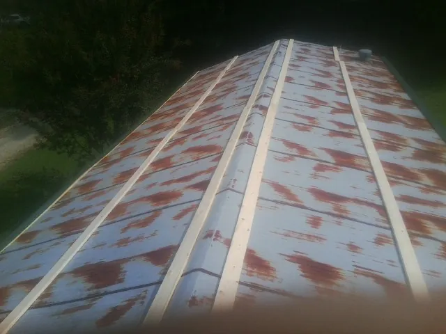 Rusted metal roof panels with new wood purlins before replacement — Storm Damage Roof Repair in Belchertown by Roofing Brothers