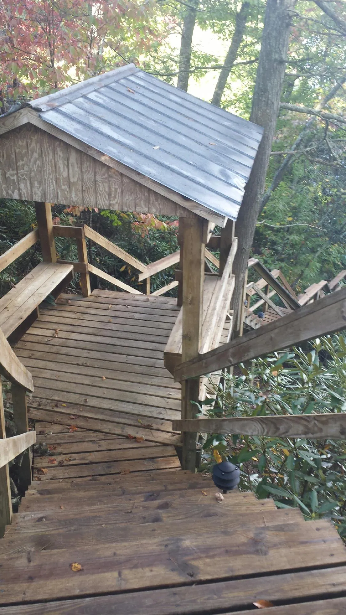 Metal roofed shelter over wooden steps on a wooded walkway — Skylight Repair & Installation work by our crew in Belchertown