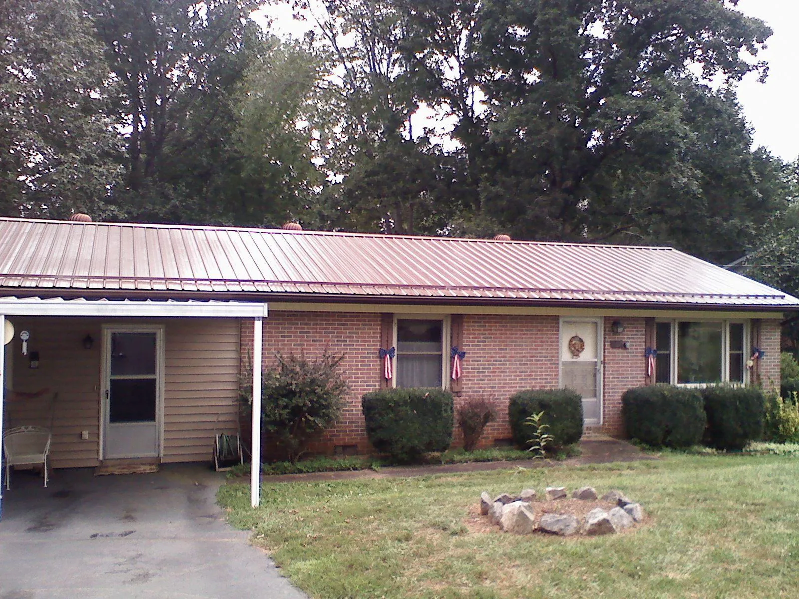 Bronze metal roof and carport on a brick ranch home — Roof Repair work by our crew in Belchertown